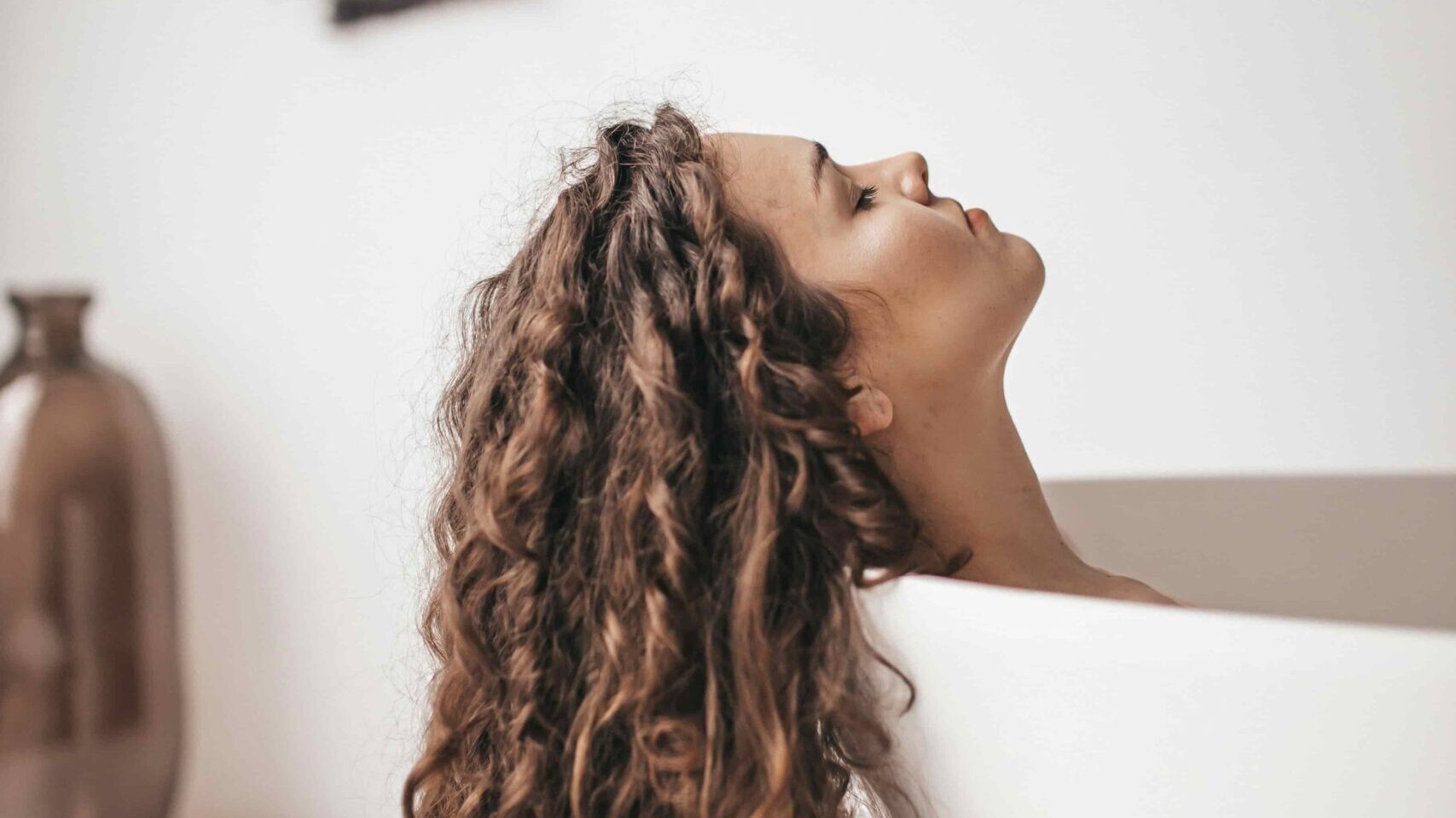 mujer cabello curly castaño mujer cabello curly castaño en la bañera